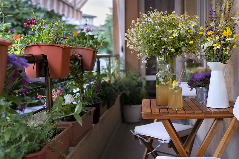 Mit Blühpflanzen dekorierter Balkon mit Sitzecke